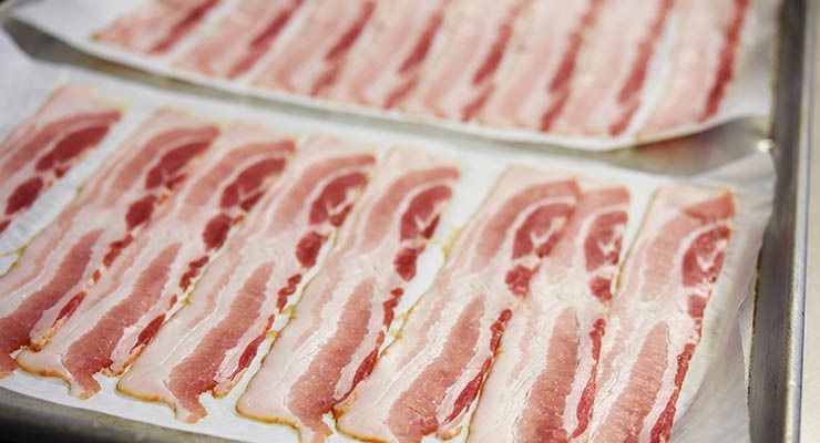 Traditional raw bacon on pans before cooking