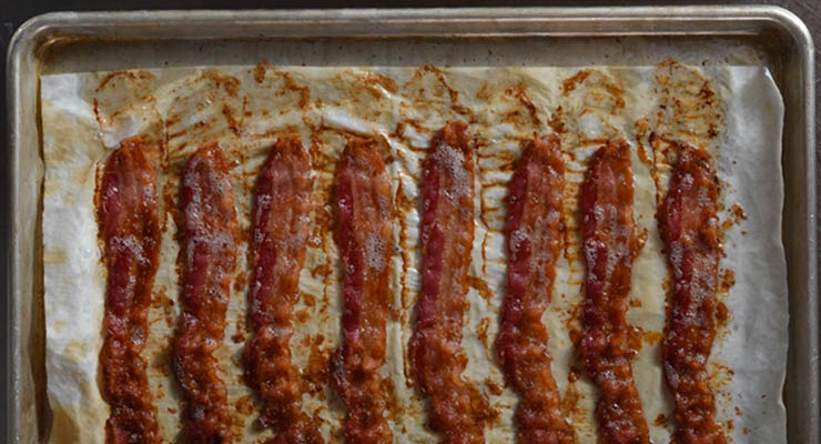 Traditional raw bacon cooked on pan